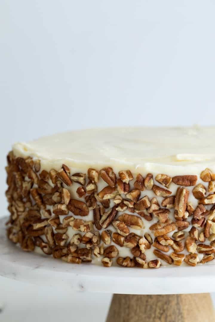 close up carrot cake dotted with pecans