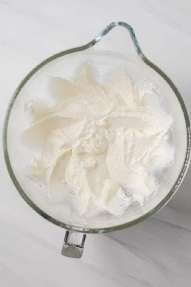 Sugar, butter, and oil creamed in glass bowl.