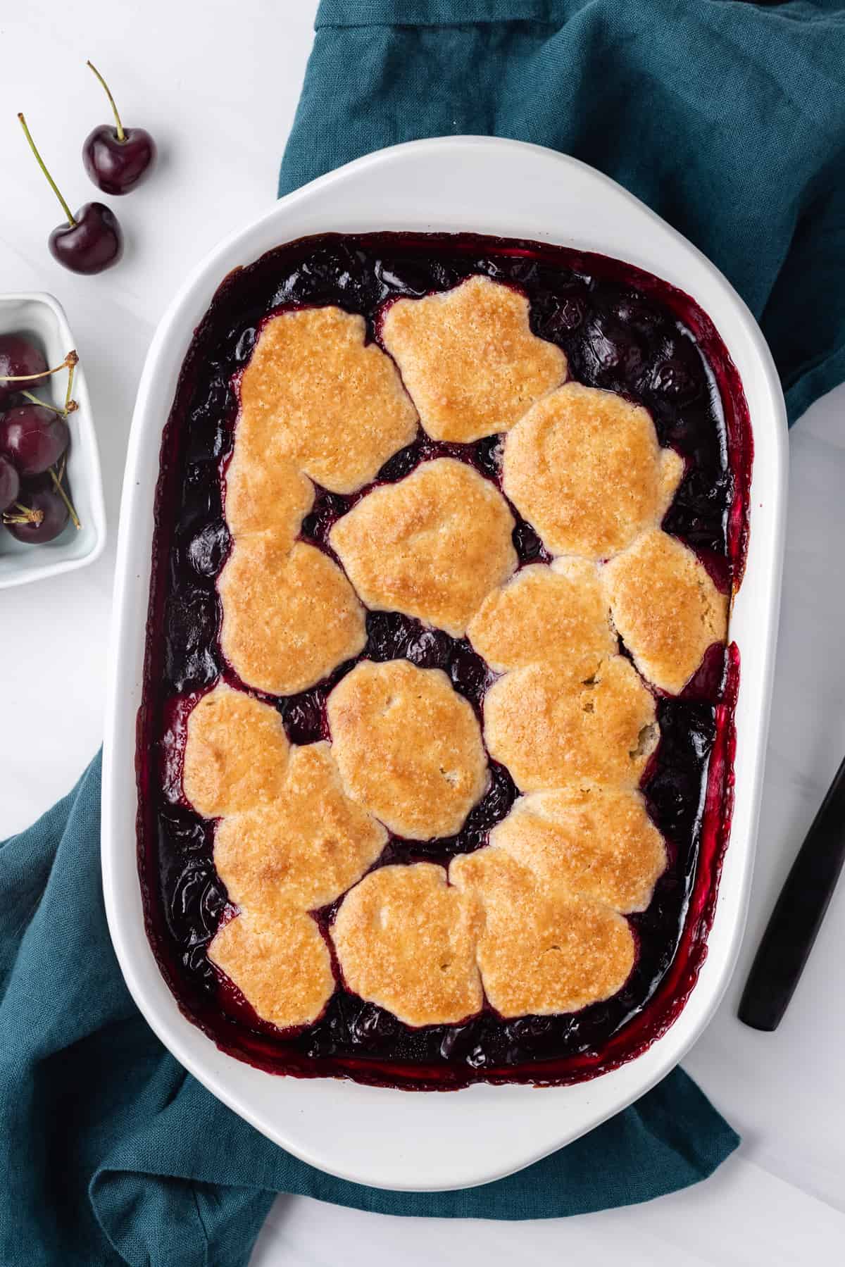 Freshly baked cherry cobbler in a white baking dish