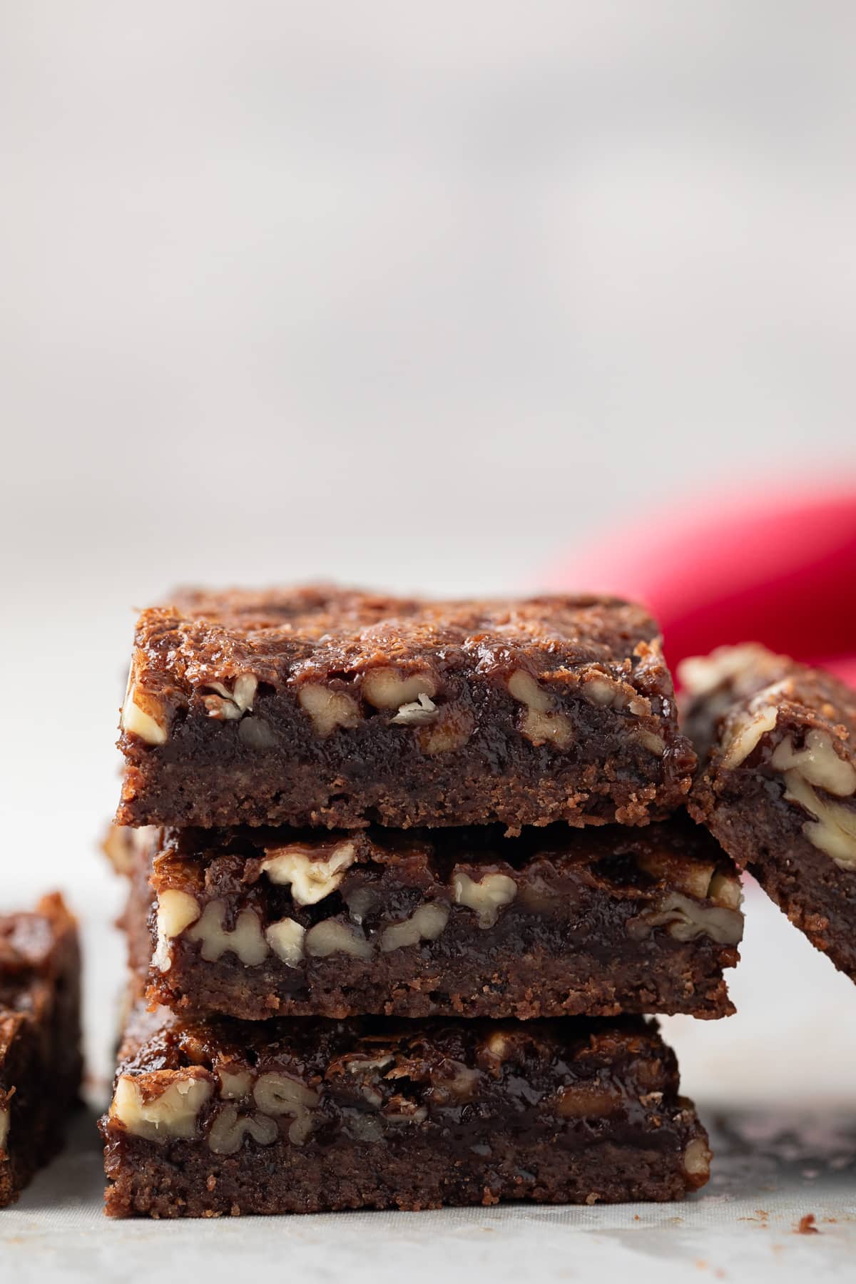Three chocolate bourbon pecan bars stacked.