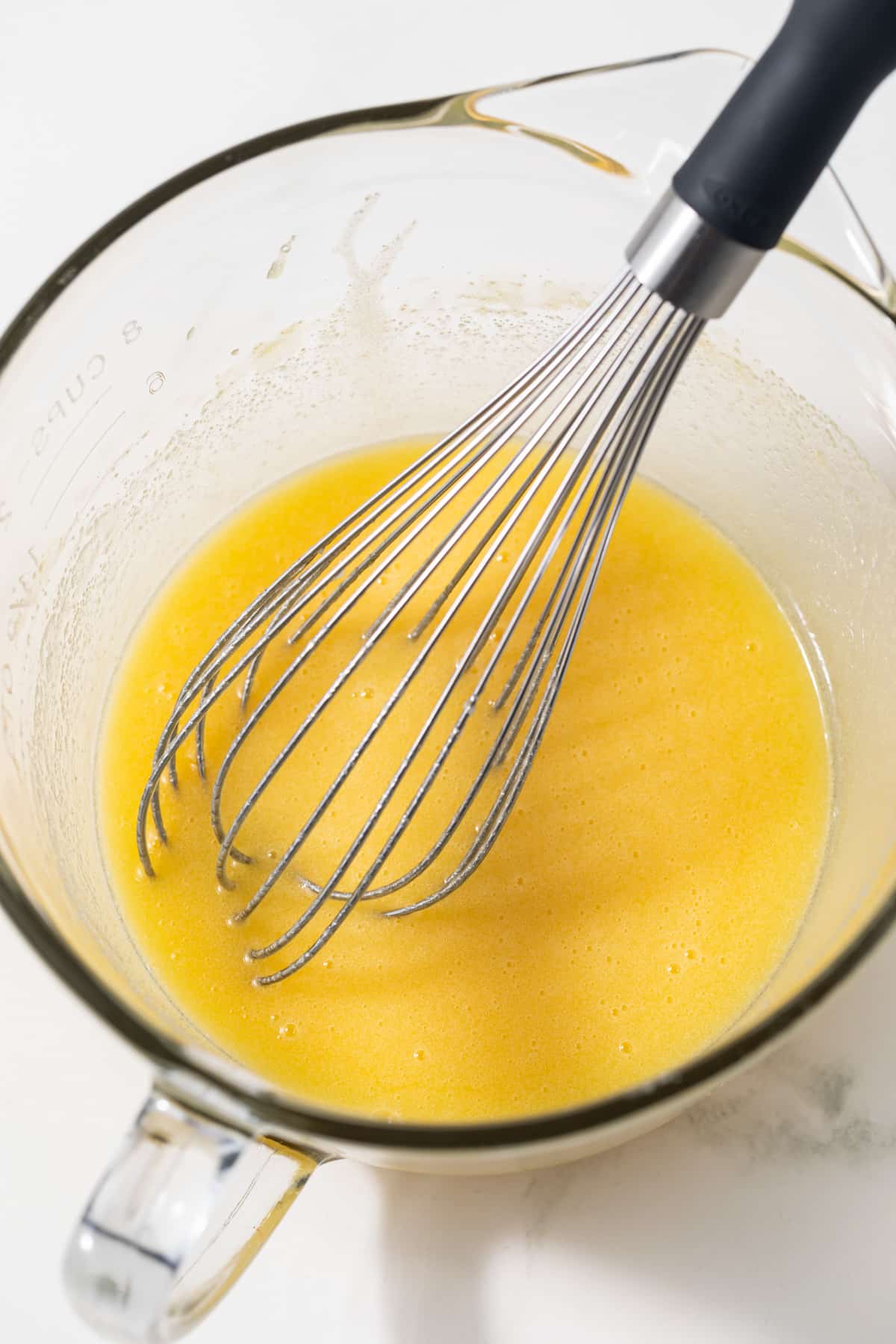 Wet ingredients mixed in glass bowl.