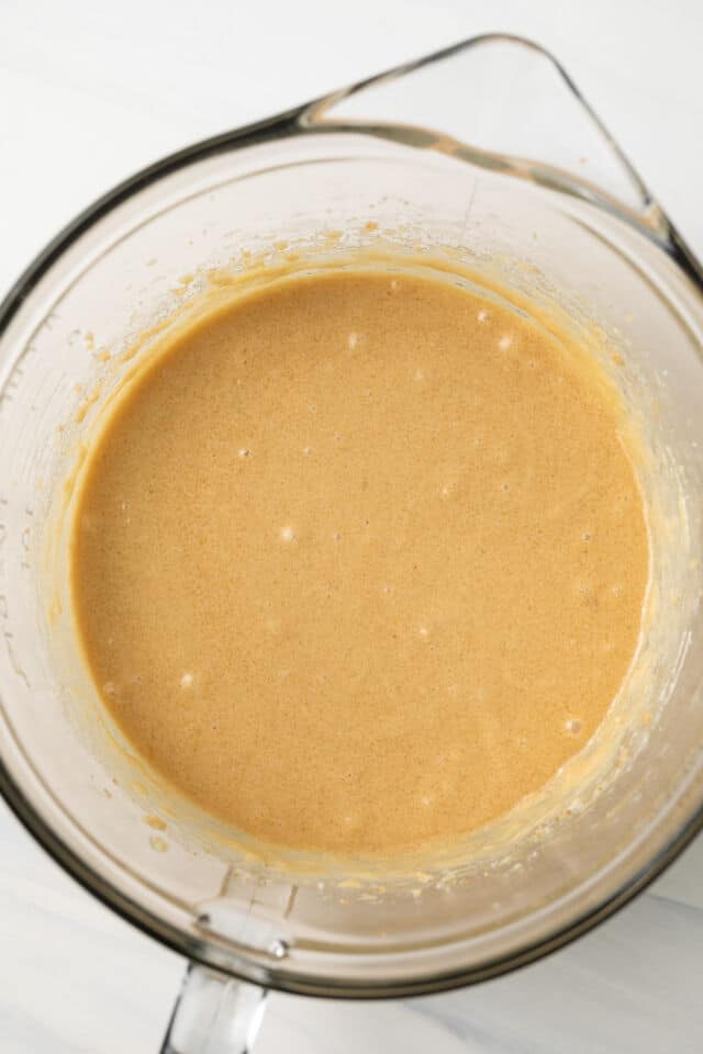 Wet ingredients for cupcakes mixed in glass bowl.