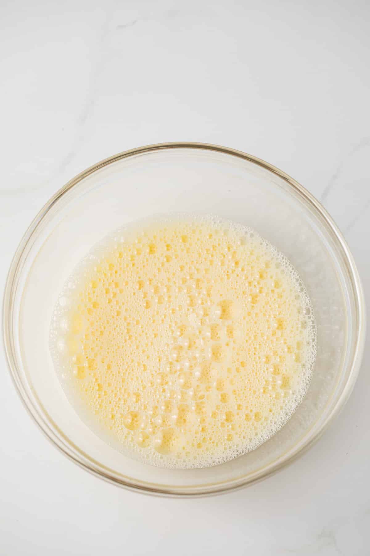 Frothy eggs in glass bowl.