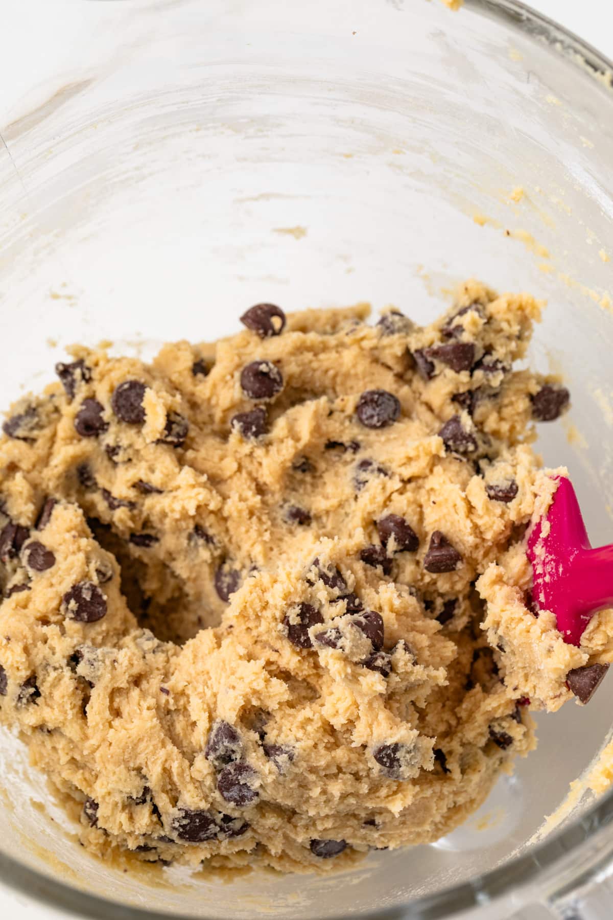 Chocolate chip cookie dough in a glass bowl.