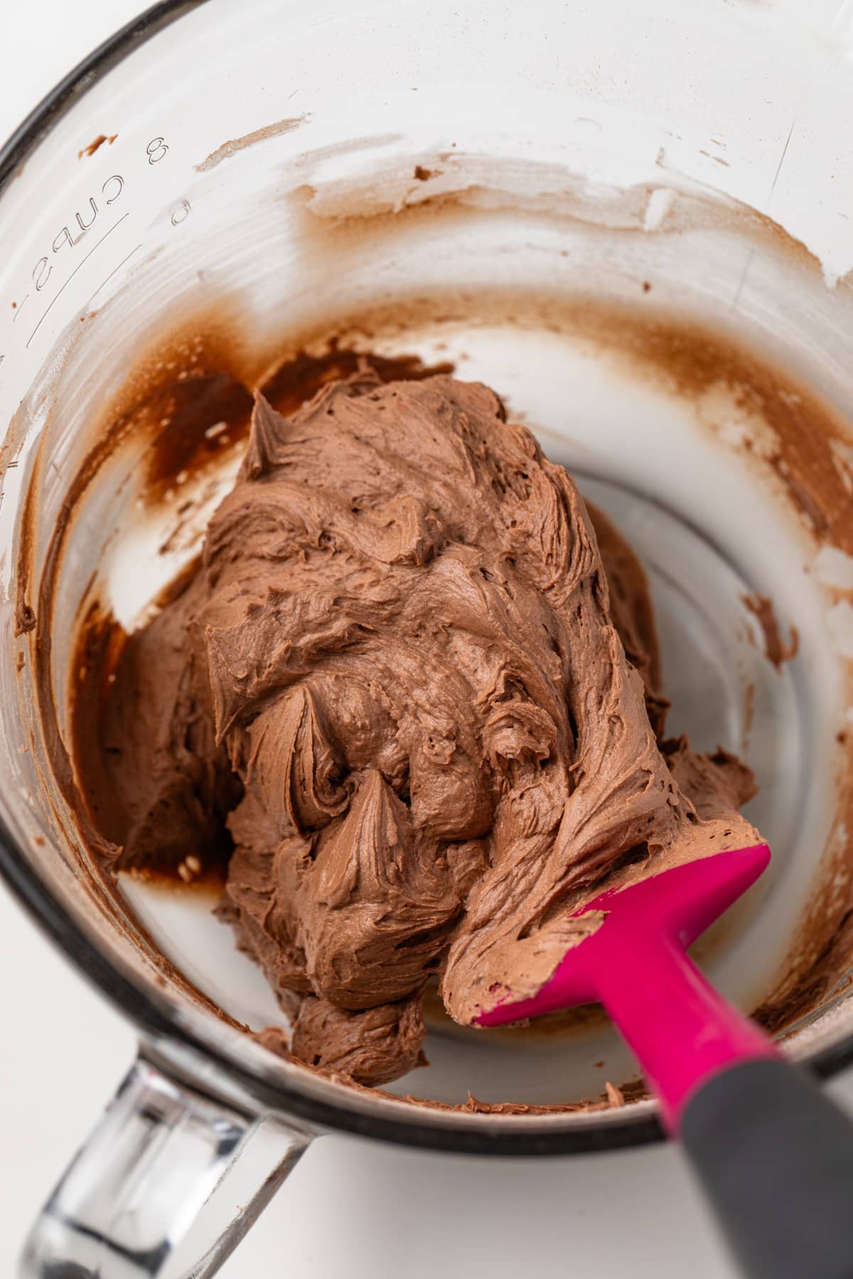 Chocolate frosting in a glass bowl.
