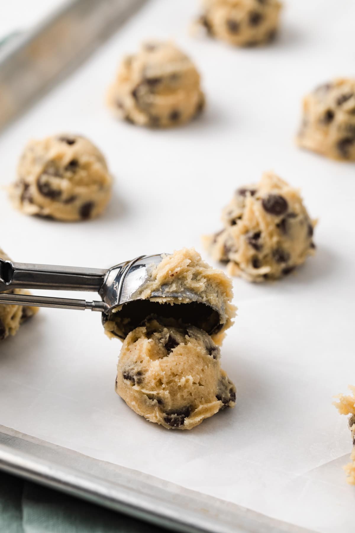 scooping cookie dough on baking sheet