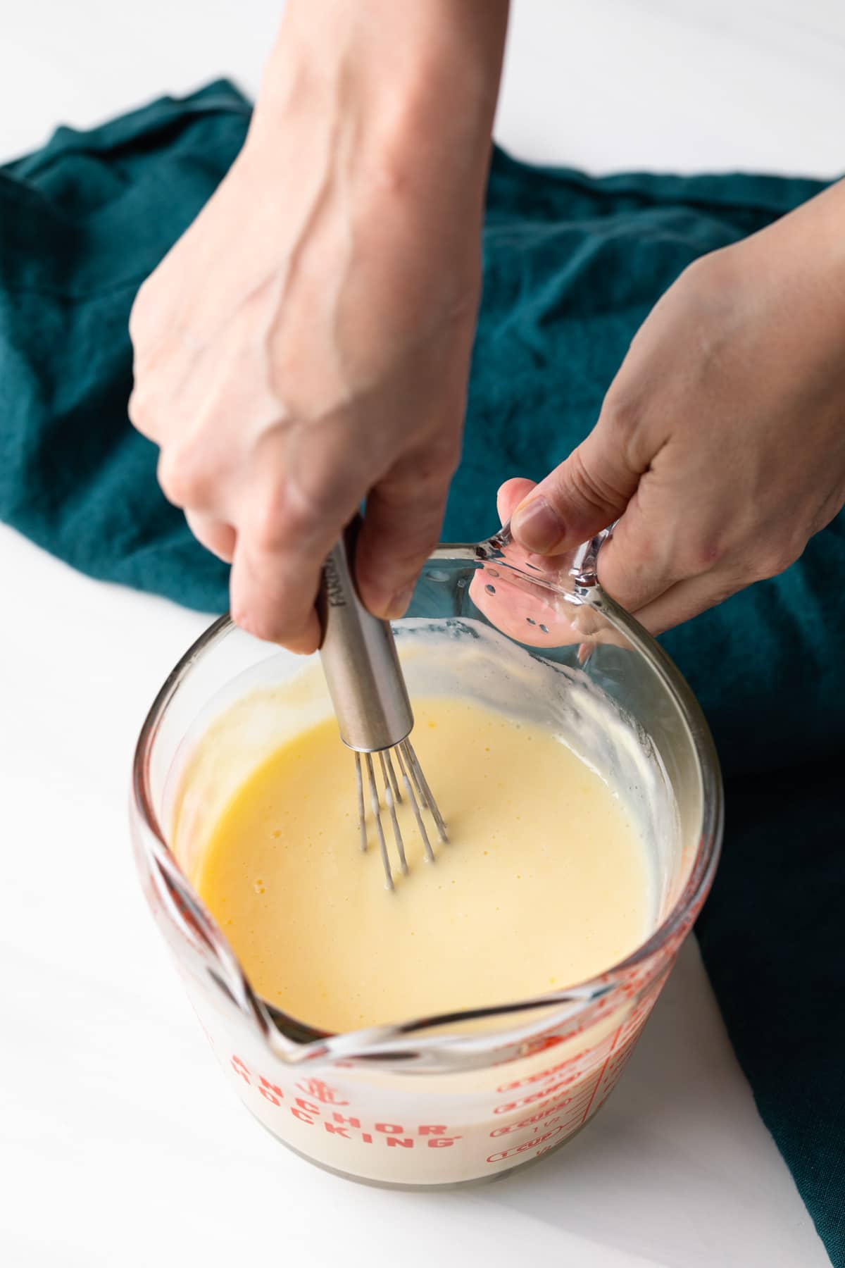 mixing wet ingredients with a whisk in glass bowl