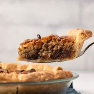 Slice being removed from chocolate chip pie.