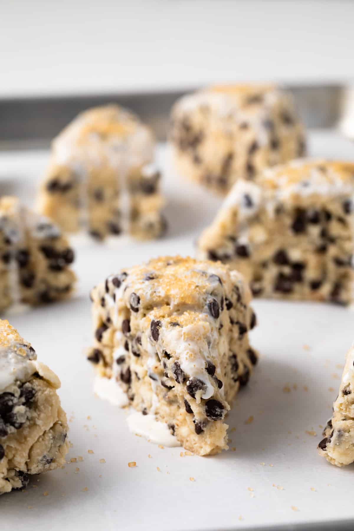 Unbaked chocolate chip scone with cream and sugar on top.
