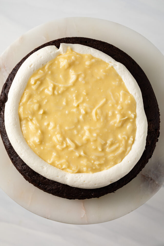 Overhead view of a chocolate cake with pastry cream and coconut frosting