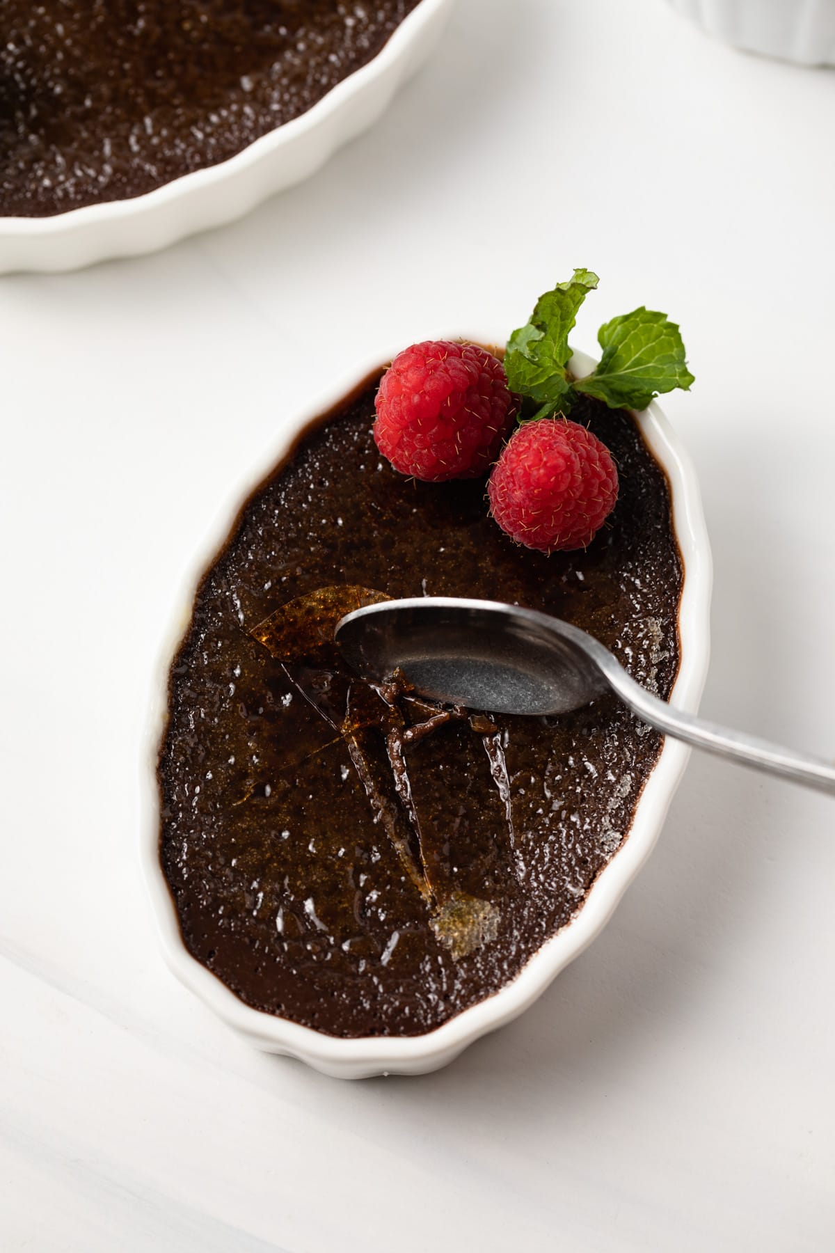 Spoon cracking chocolate creme brulee.