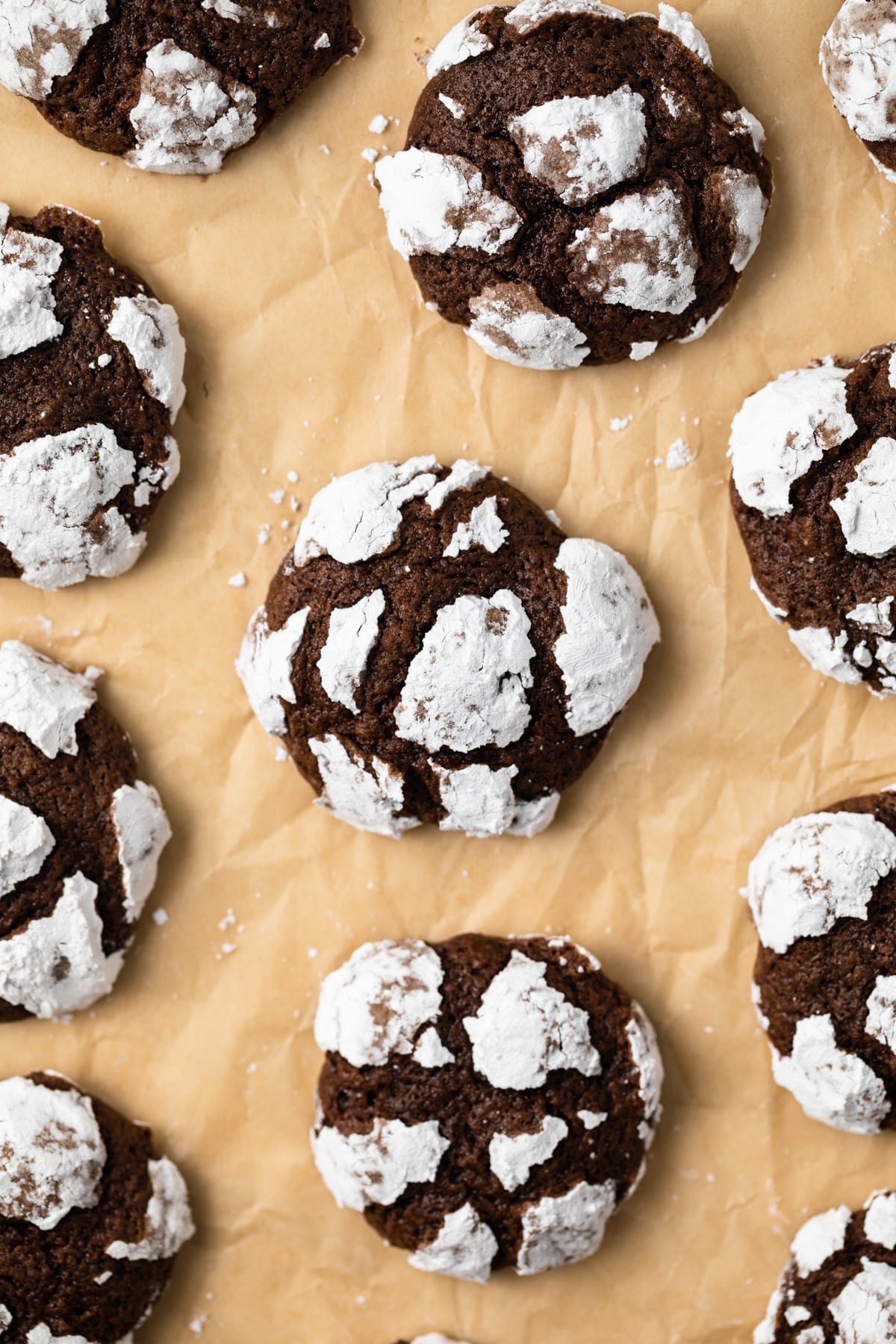 Overhead of chocolate crinkle cookies on parchment paper.