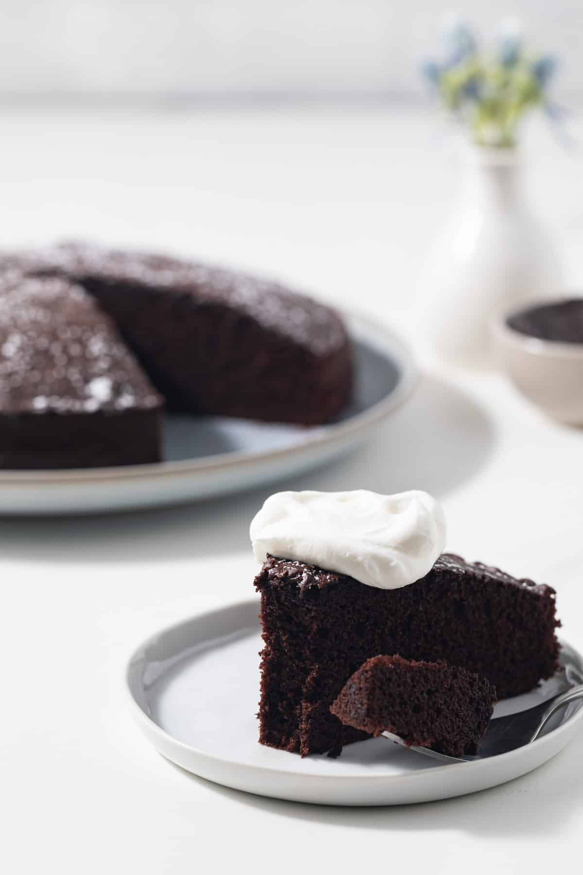 Fork taking a bite out of slice of cake.