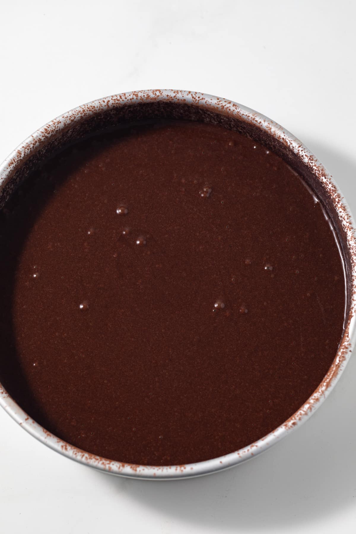 Cake batter in round baking pan.