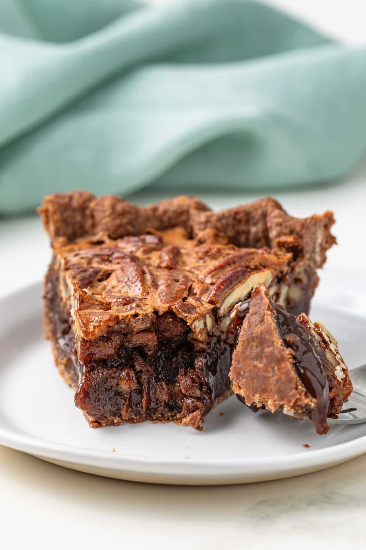 Slice of chocolate pecan pie with fork.