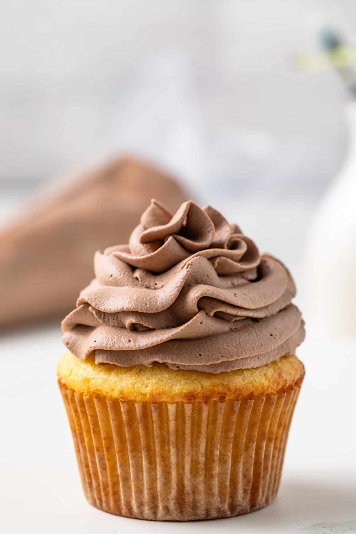 Chocolate whipped cream on a vanilla cupcake.