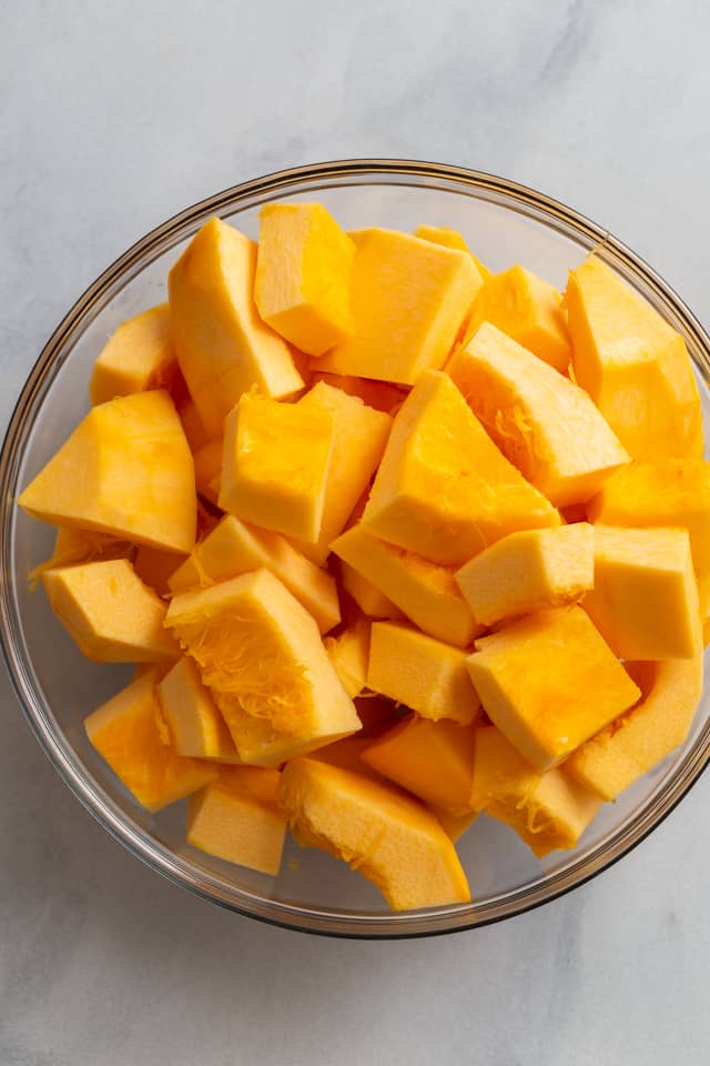 overhead view of chopped pumpkin in glass bowl
