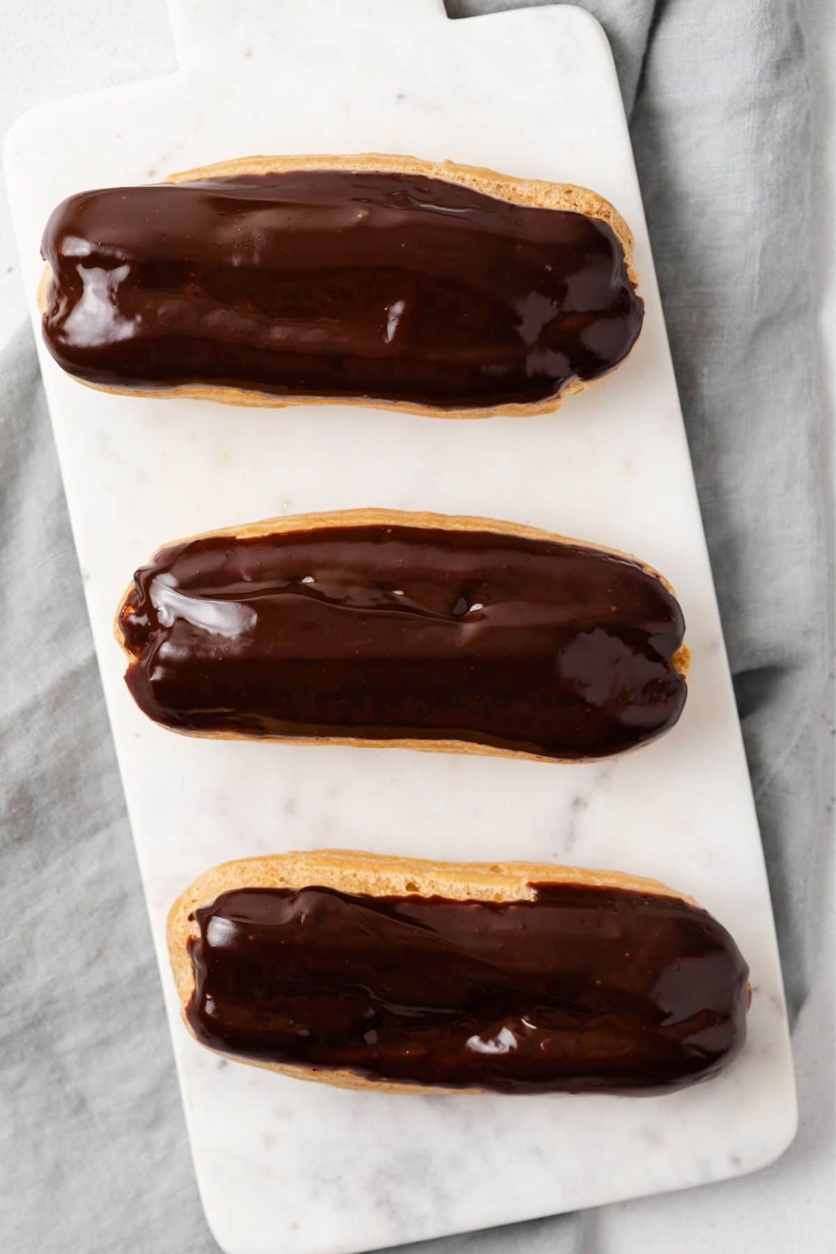 Overhead of eclairs topped with chocolate glaze.