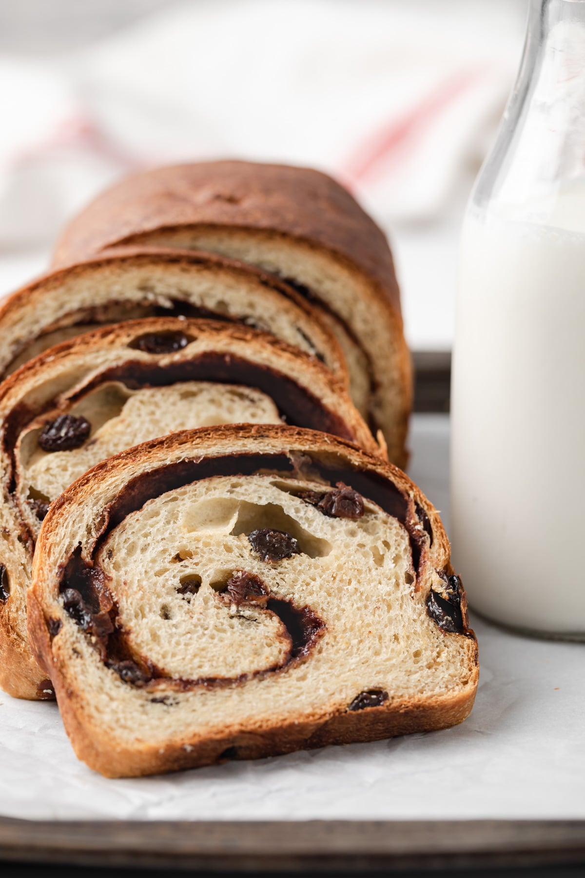 slices of cinnamon raisin bread leaned next to jar of milk