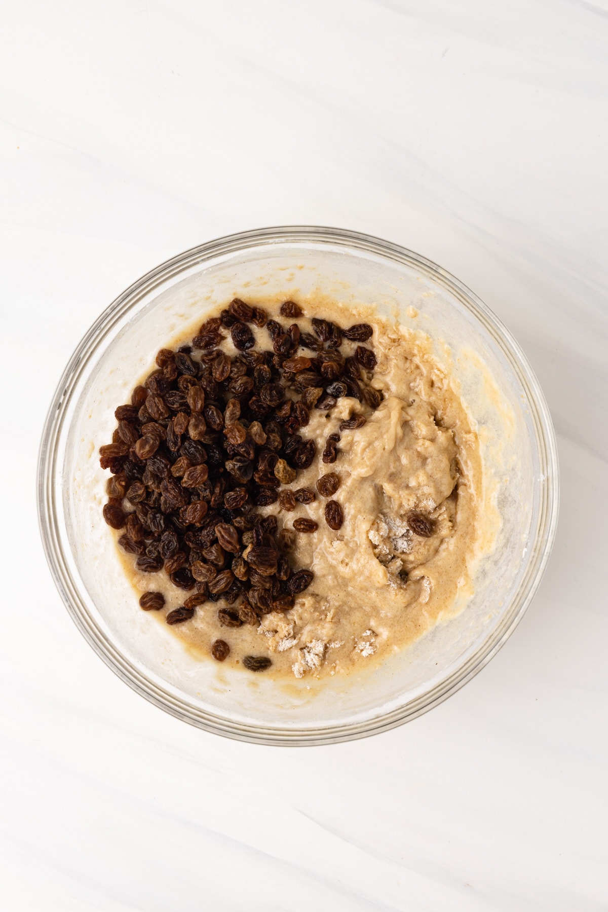Muffin batter with raisins on top.