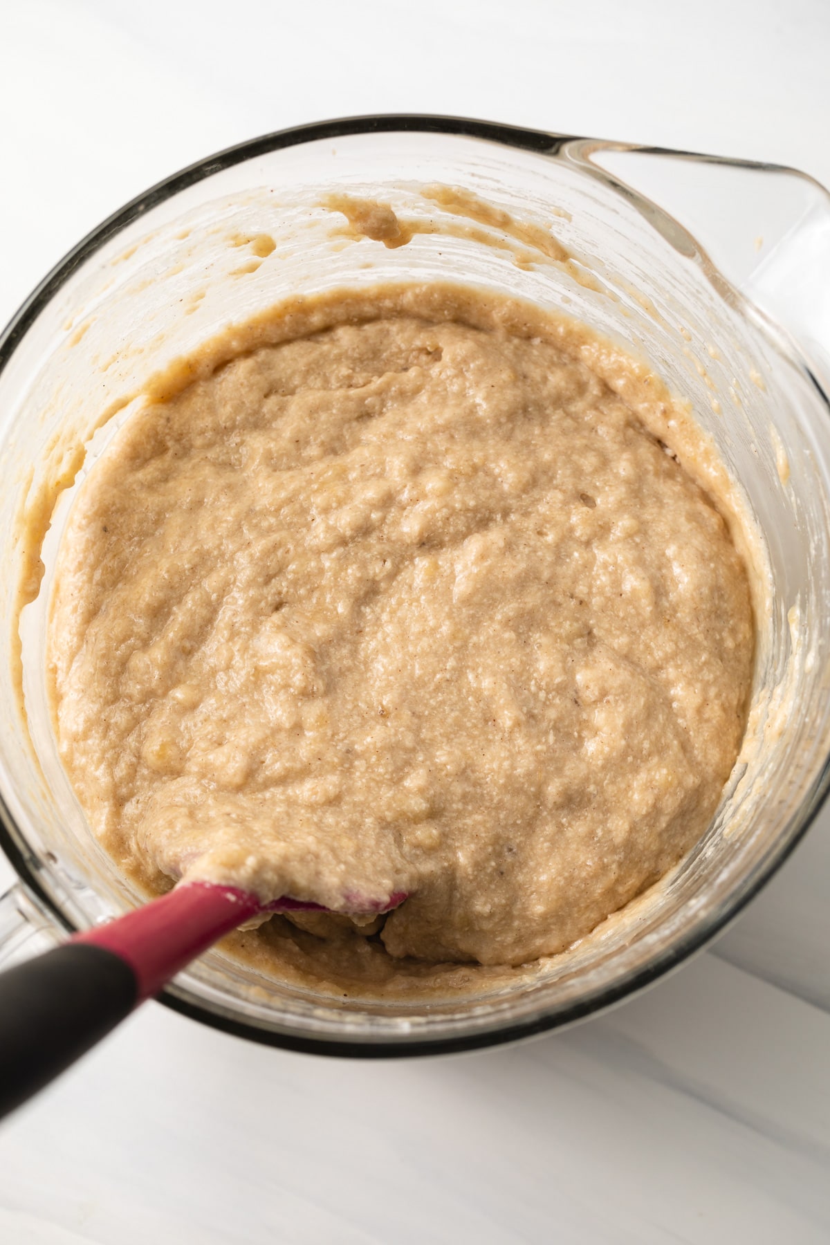 Banana bread batter in a glass bowl.