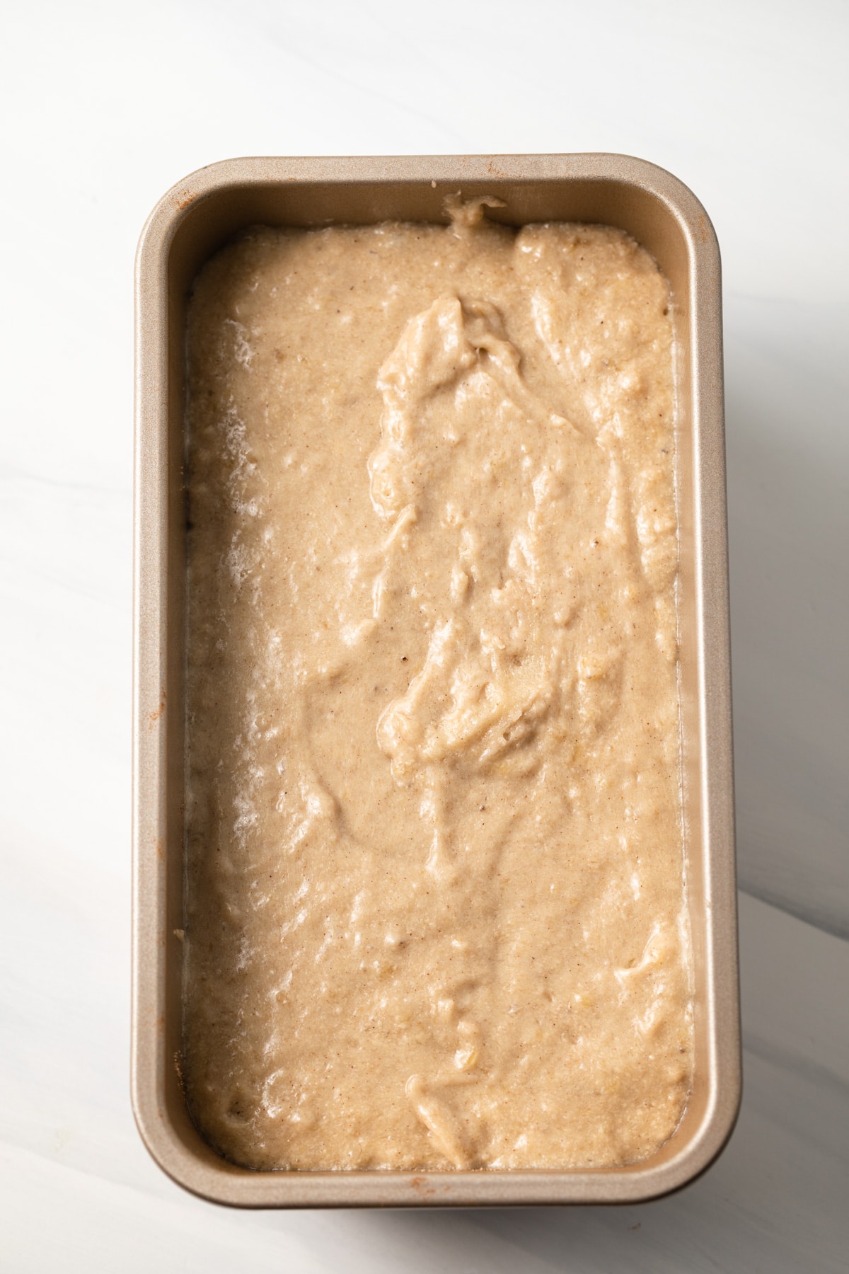 Banana bread batter in a loaf pan.