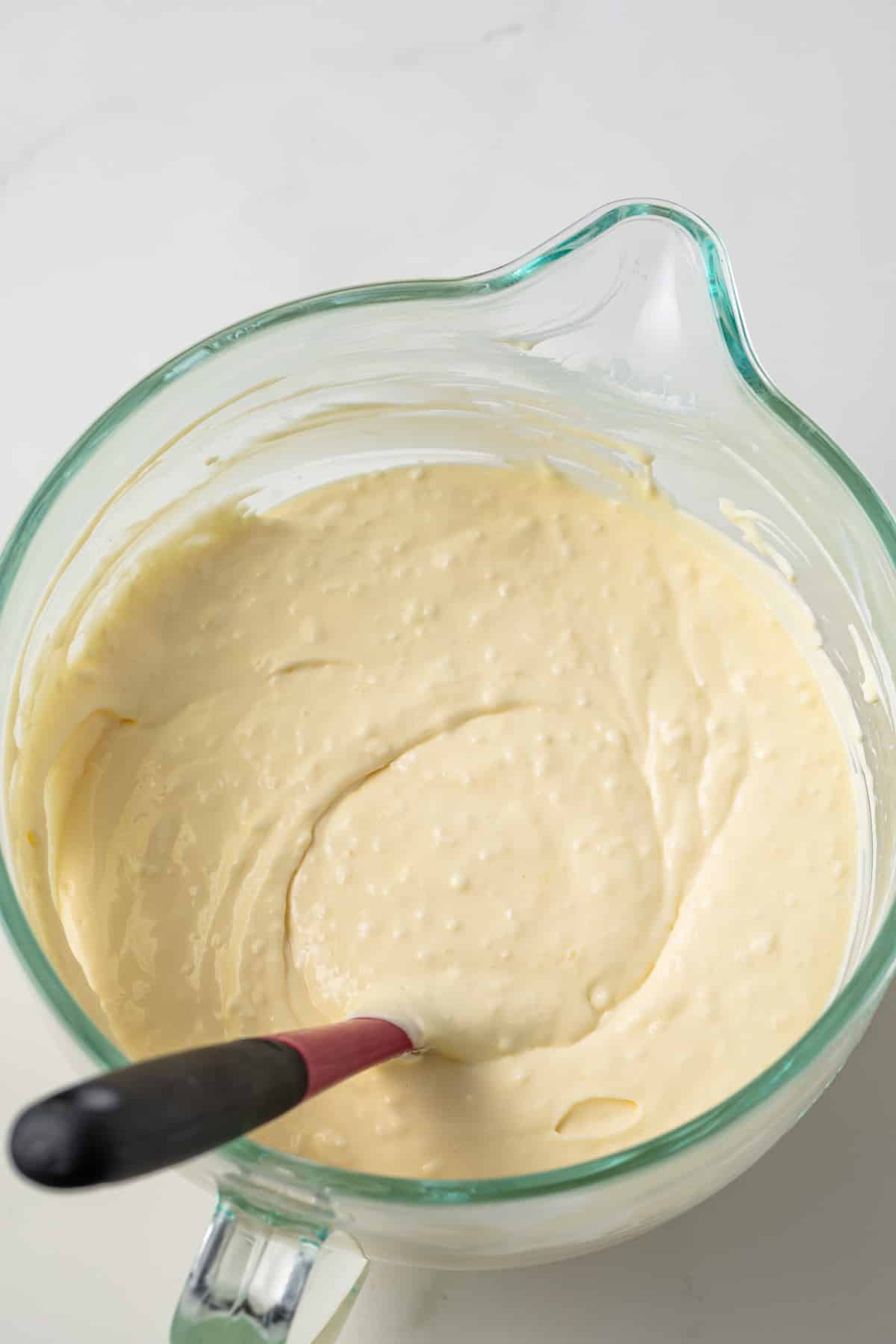 Coconut cheesecake filling in glass bowl.