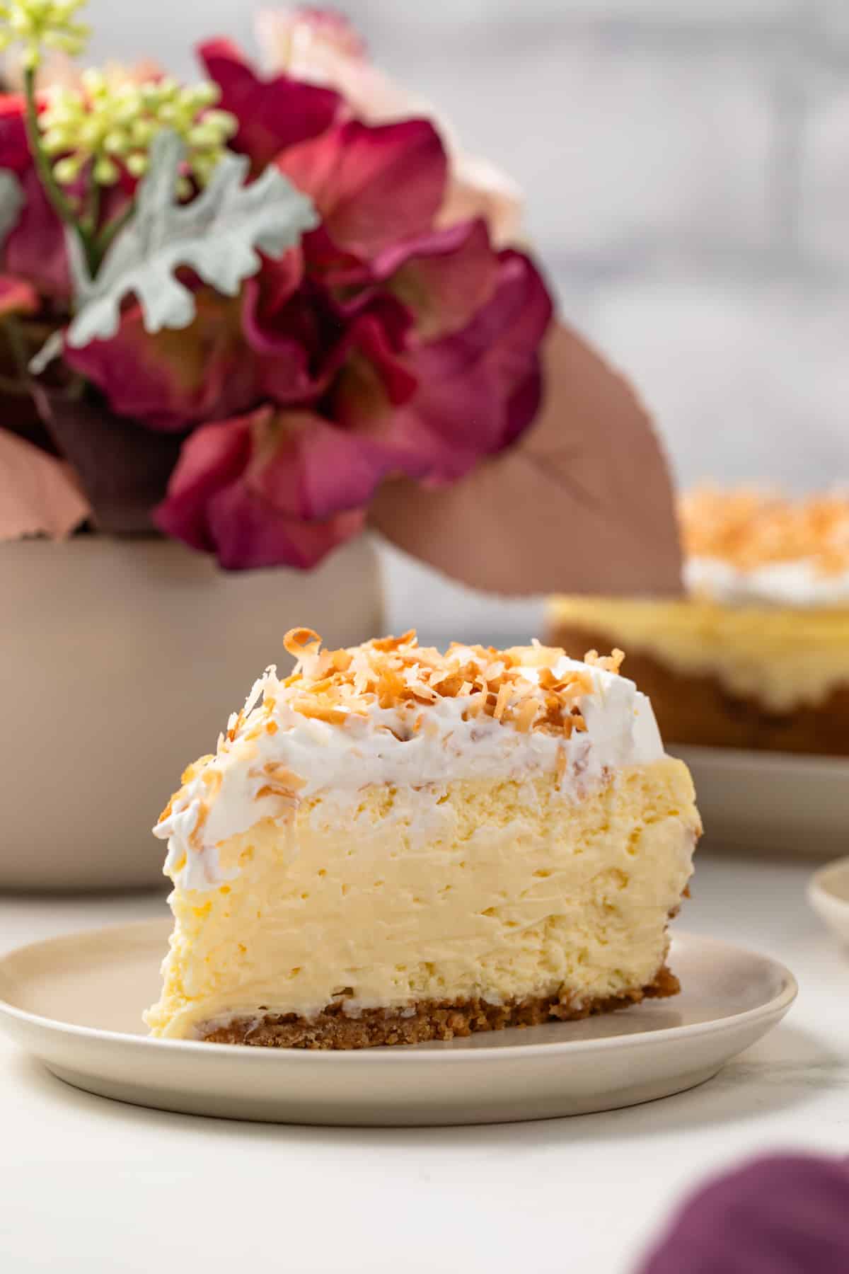 Slice of coconut cheesecake on plate.