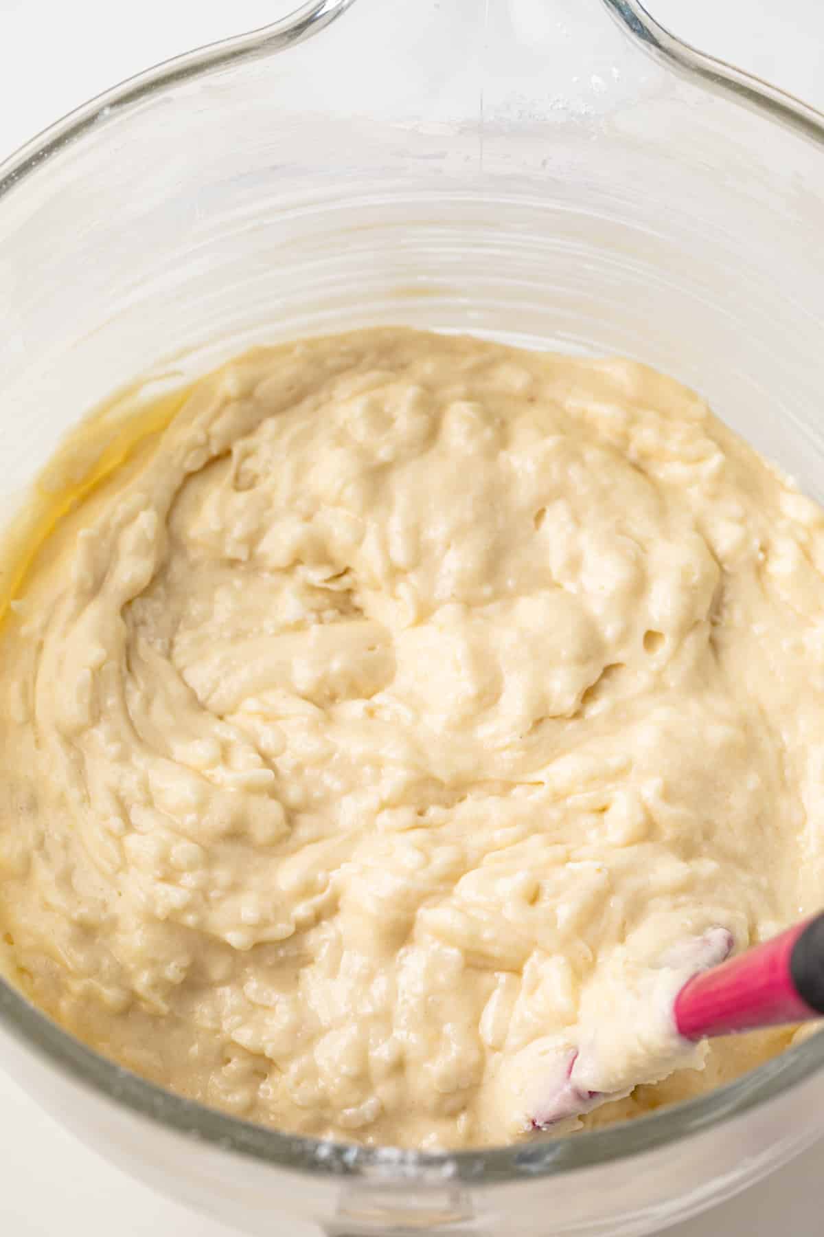 Coconut cupcake batter in a glass bowl.