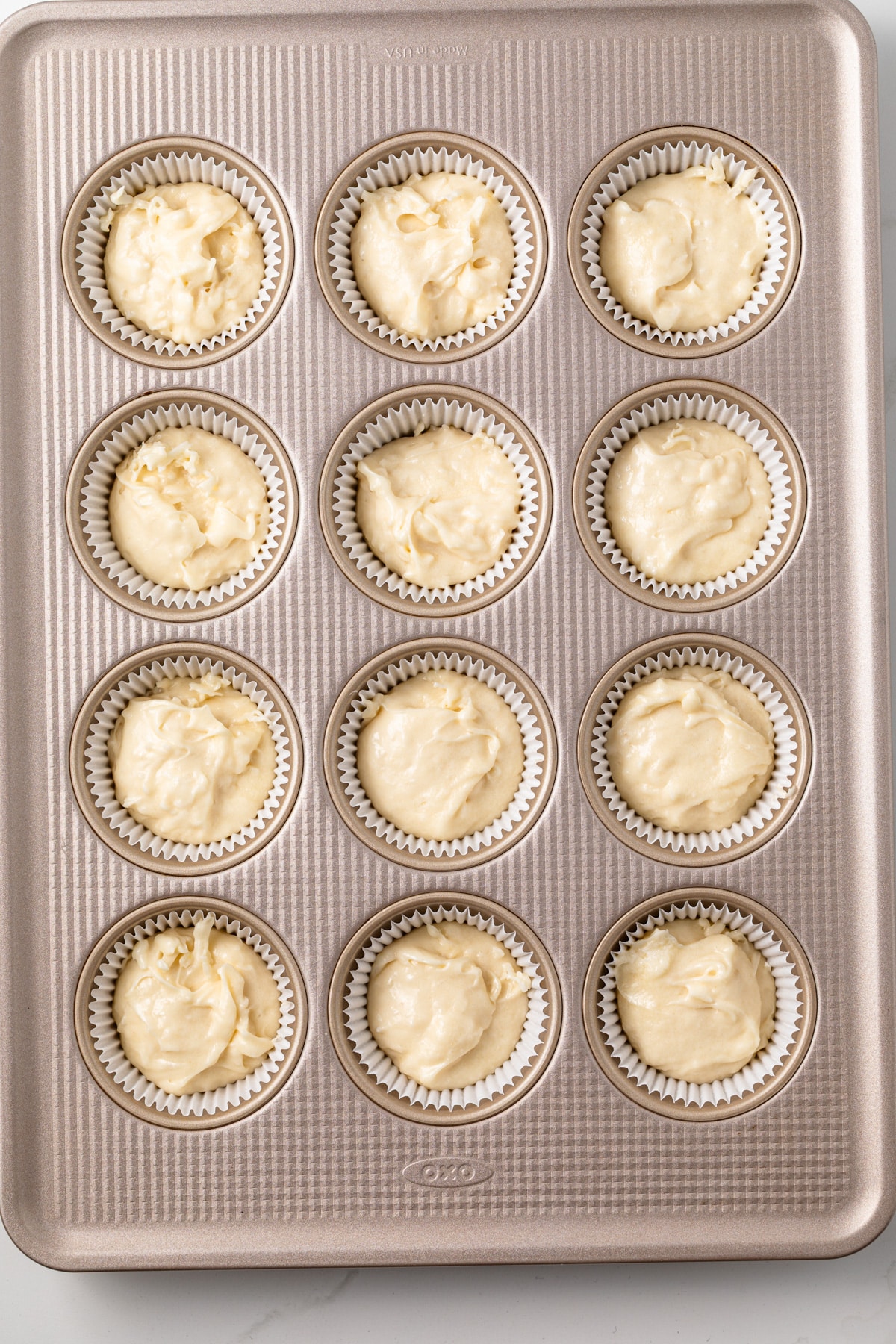 Unbaked cupcake batter in a lined muffin pan.