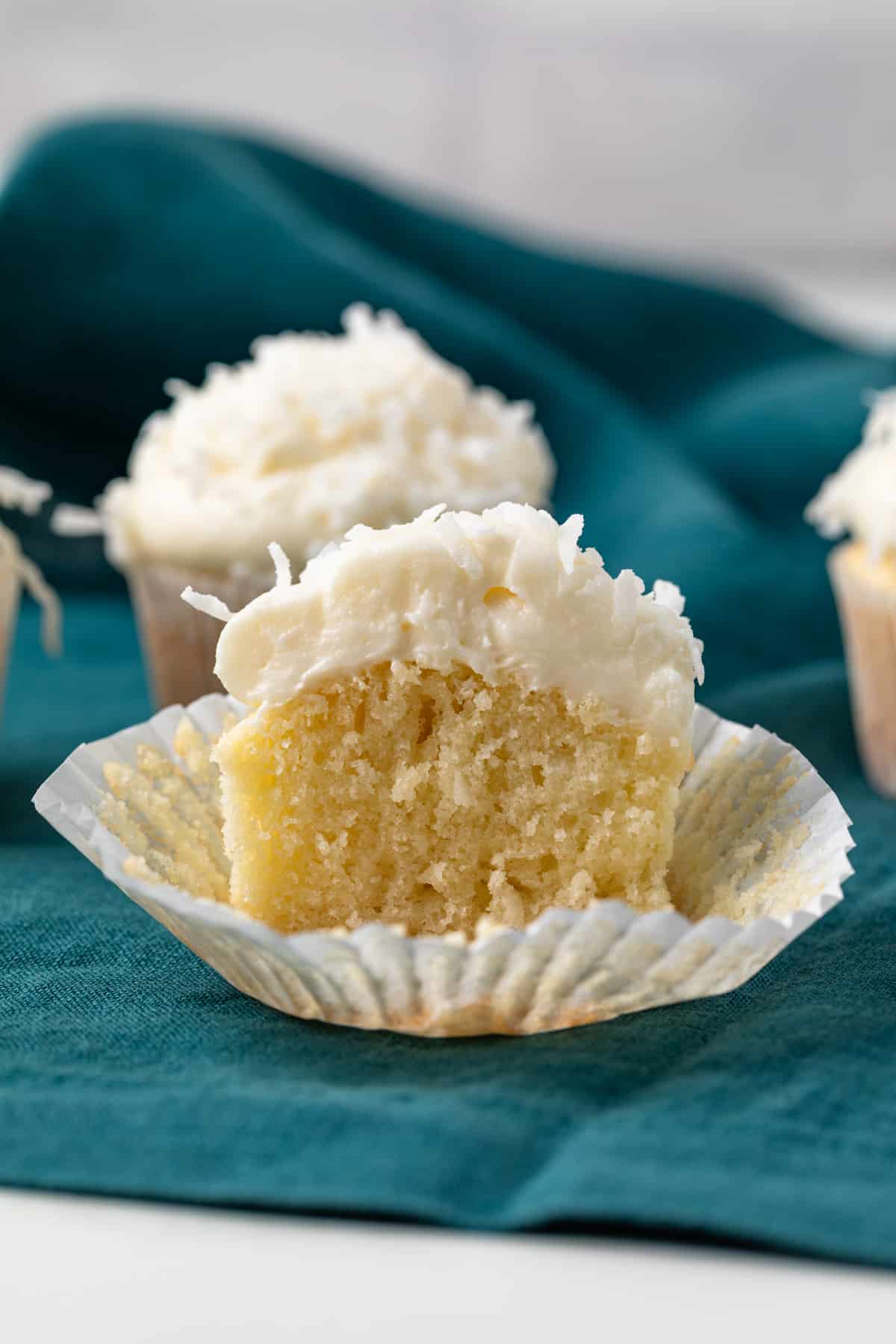 Coconut cupcake cut in half so the inside is visible.