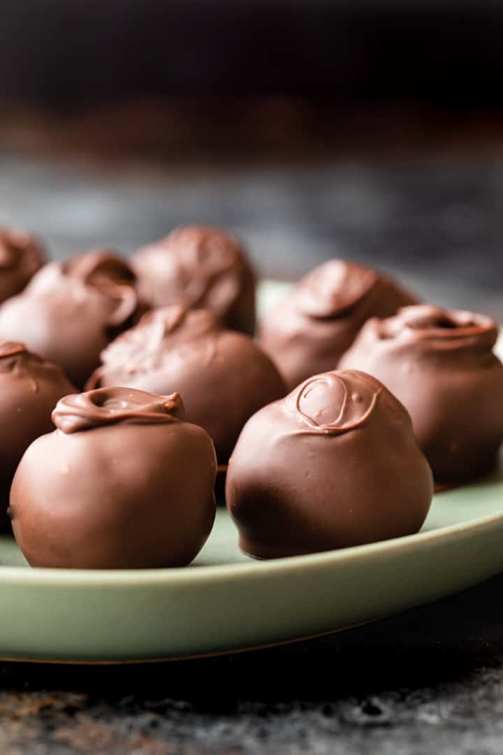 side view of cookie dough truffles on a green plate
