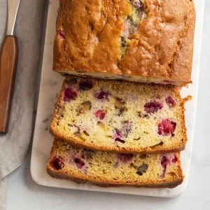 overhead view of cranberry walnut bread sliced on a cutting board