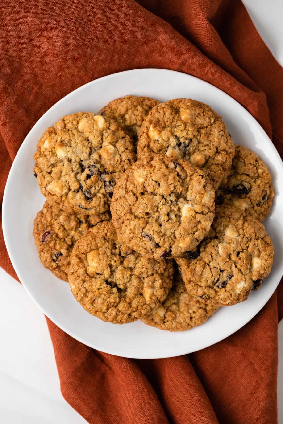 Overhead view of white chocolate oatmeal cookies on a white plate