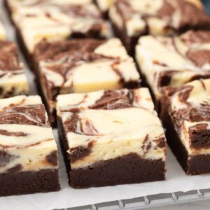 Close up of fudgy cheesecake brownies on a wire rack.