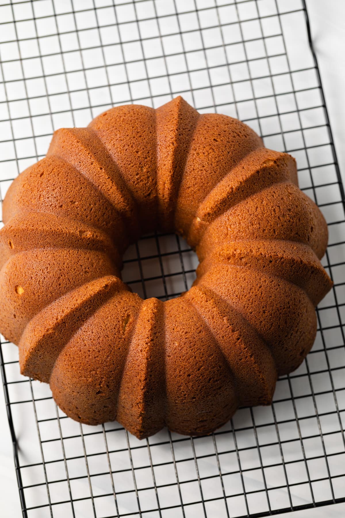 Baked pound cake on wire rack.