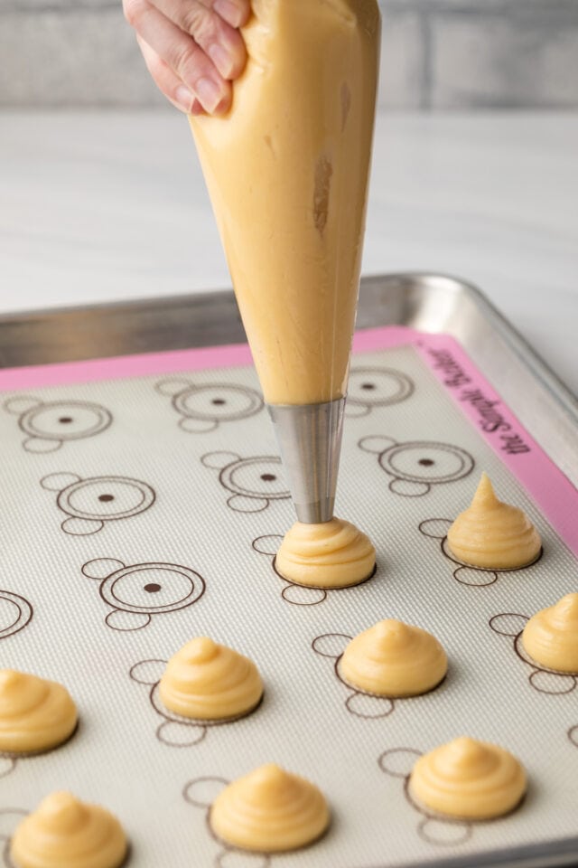 Choux dough piped on baking sheet.