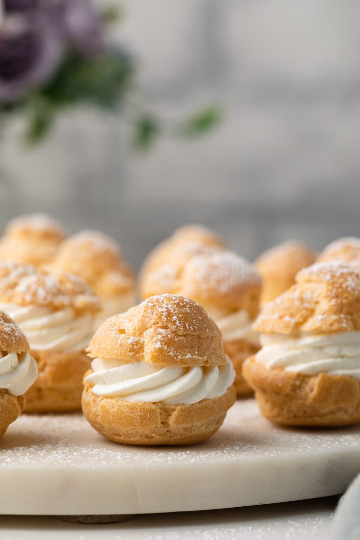 Cream puffs dusted with powderd sugar.