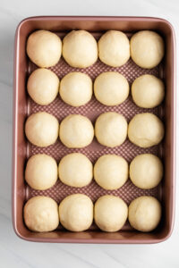 Yeast dough shaped into rolls on a baking sheet