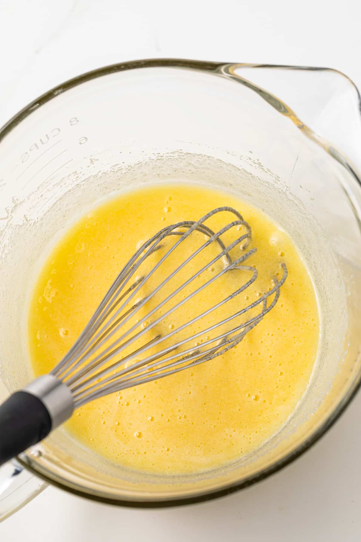 Wet ingredients mixed in a glass bowl.