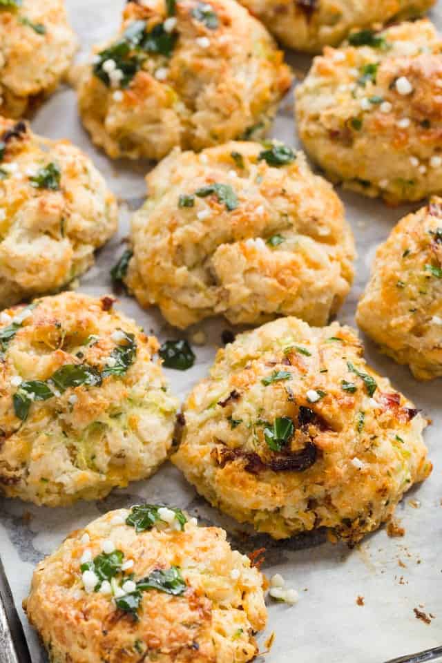 Drop Biscuits with Cheese, Zucchini, & Tomato on white parchment paper.