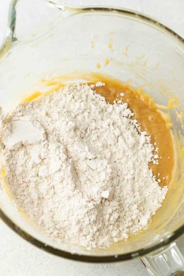 wet and dry ingredients for cookie dough in a glass bowl