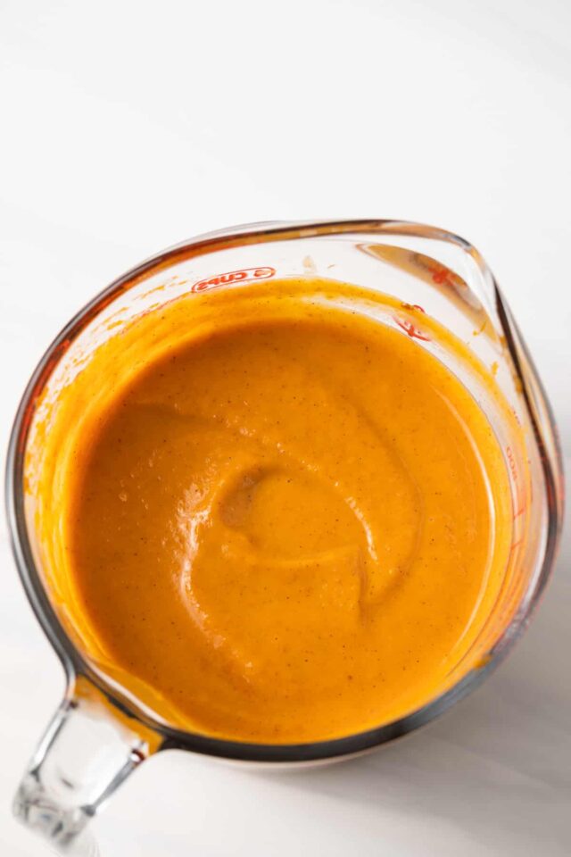 Overhead shot of pumpkin pie layer in glass measuring cup