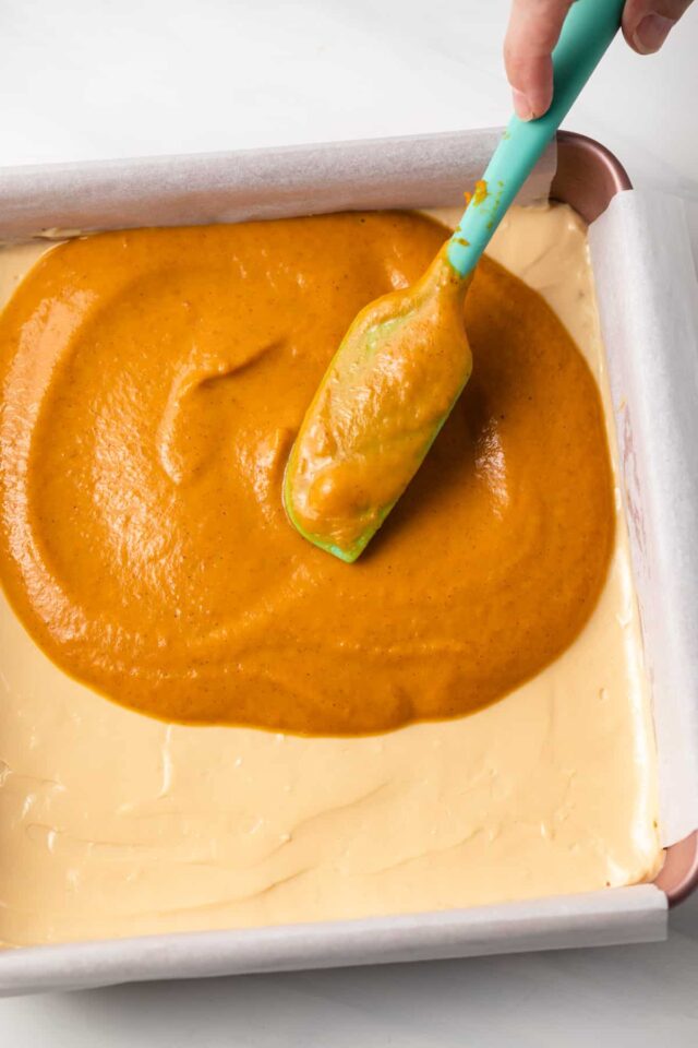 Assembling Dulce de Leche Pumpkin Bars by adding pumpkin layer