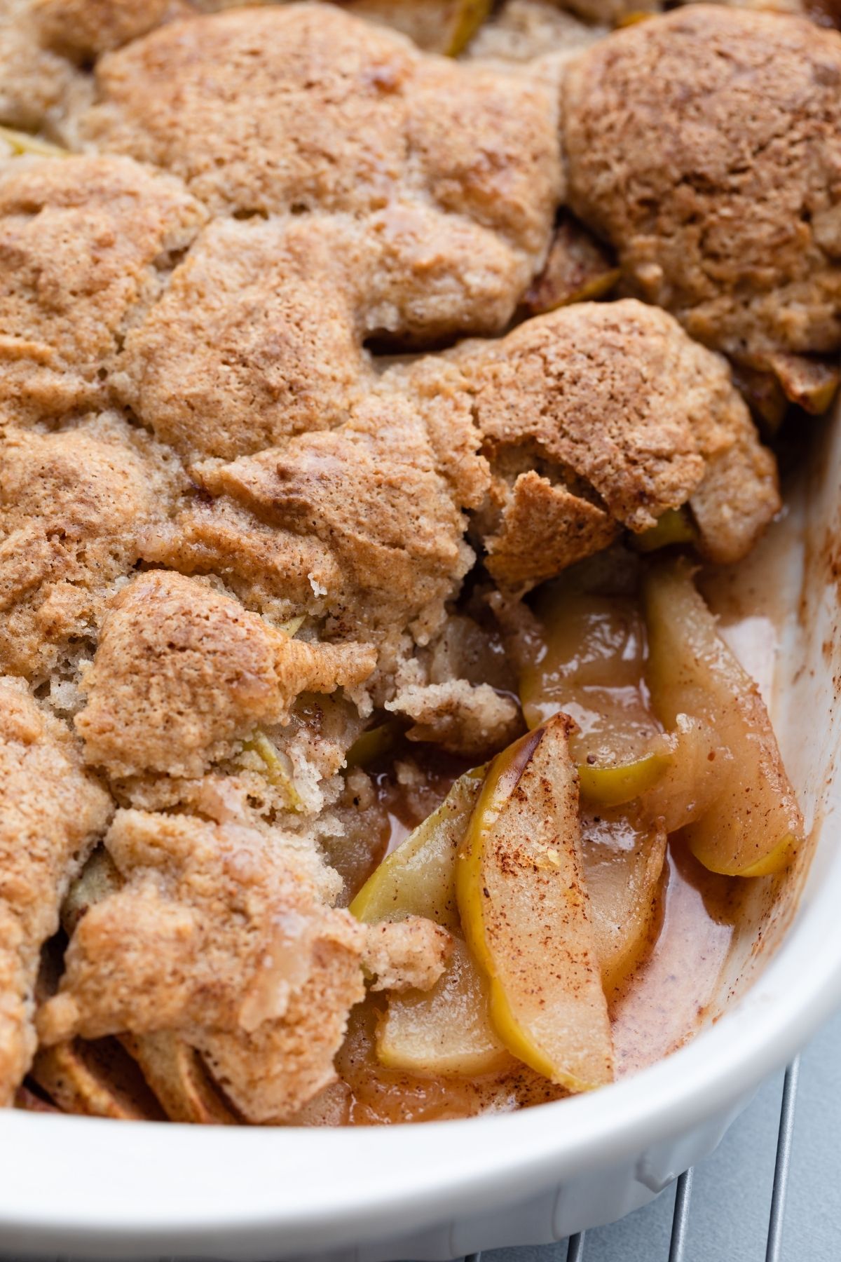 close up of a spoon scooping out apple cobbler