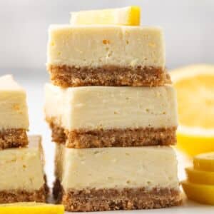 Three lemon cheesecake bars stacked.