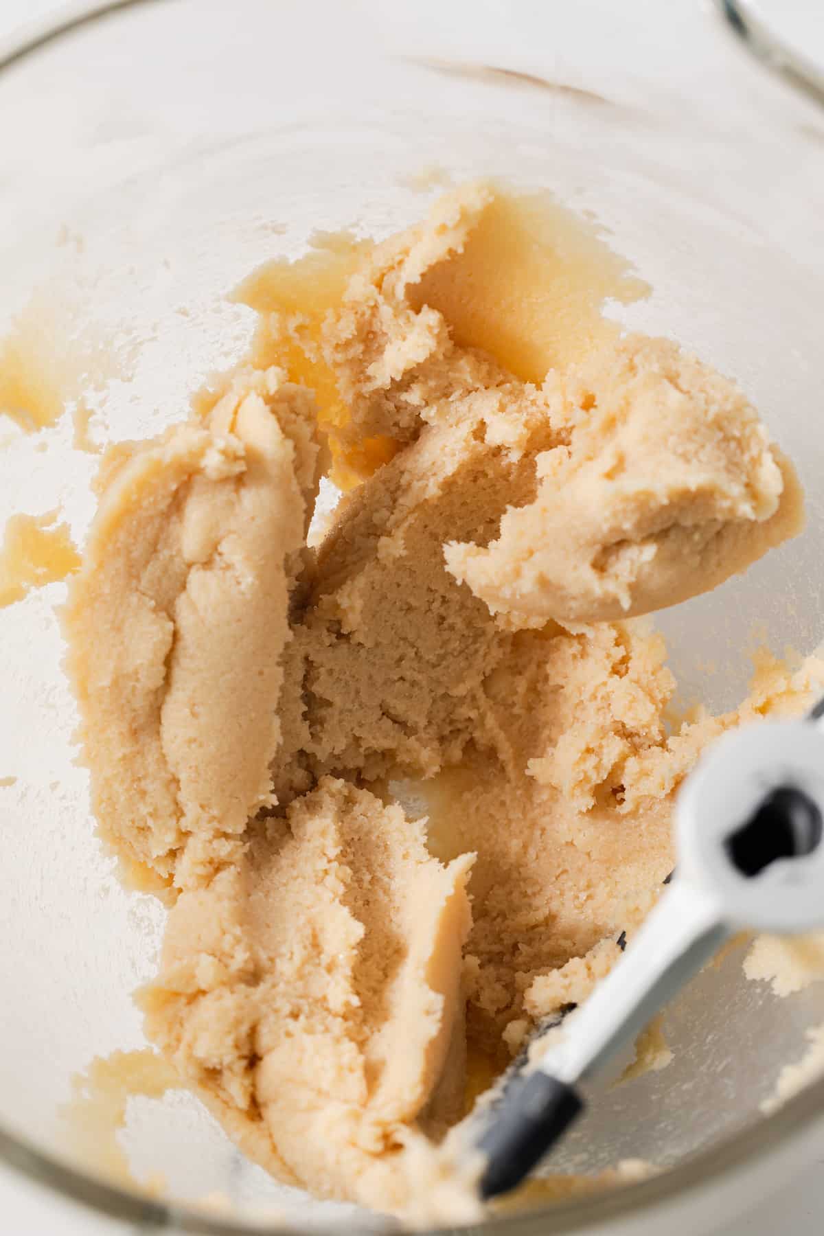 Butter and sugar creamed in glass bowl.