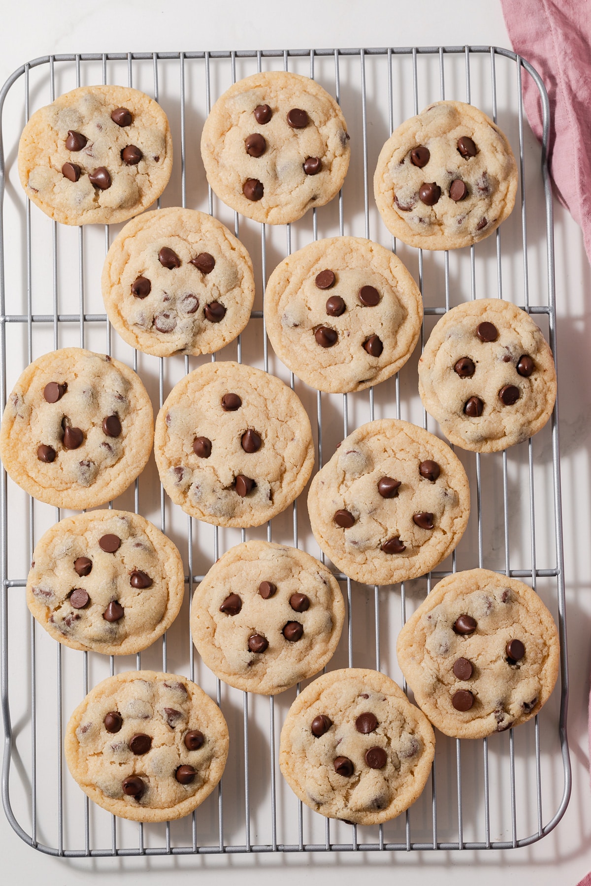 Freshly baked chocolate chip cookies on a wire rack.