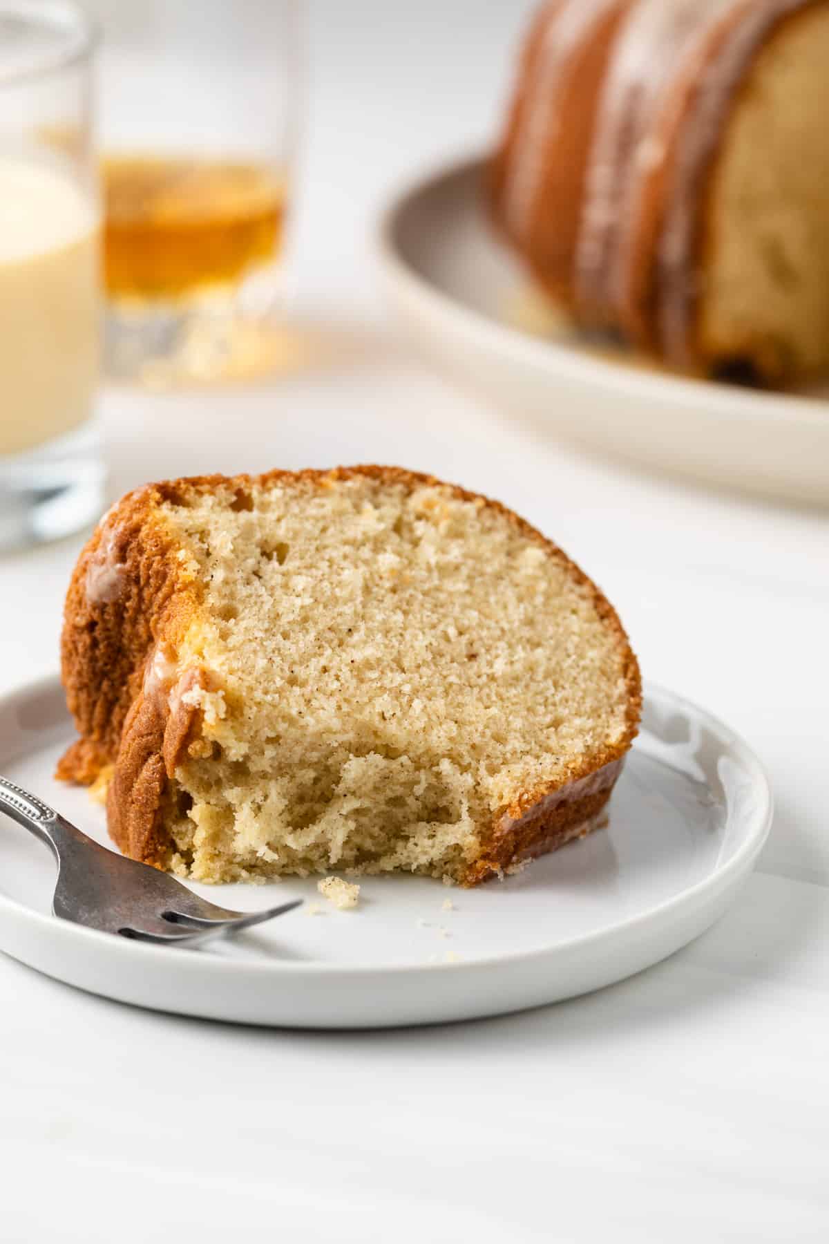A slice of eggnog bundt cake on a white plate