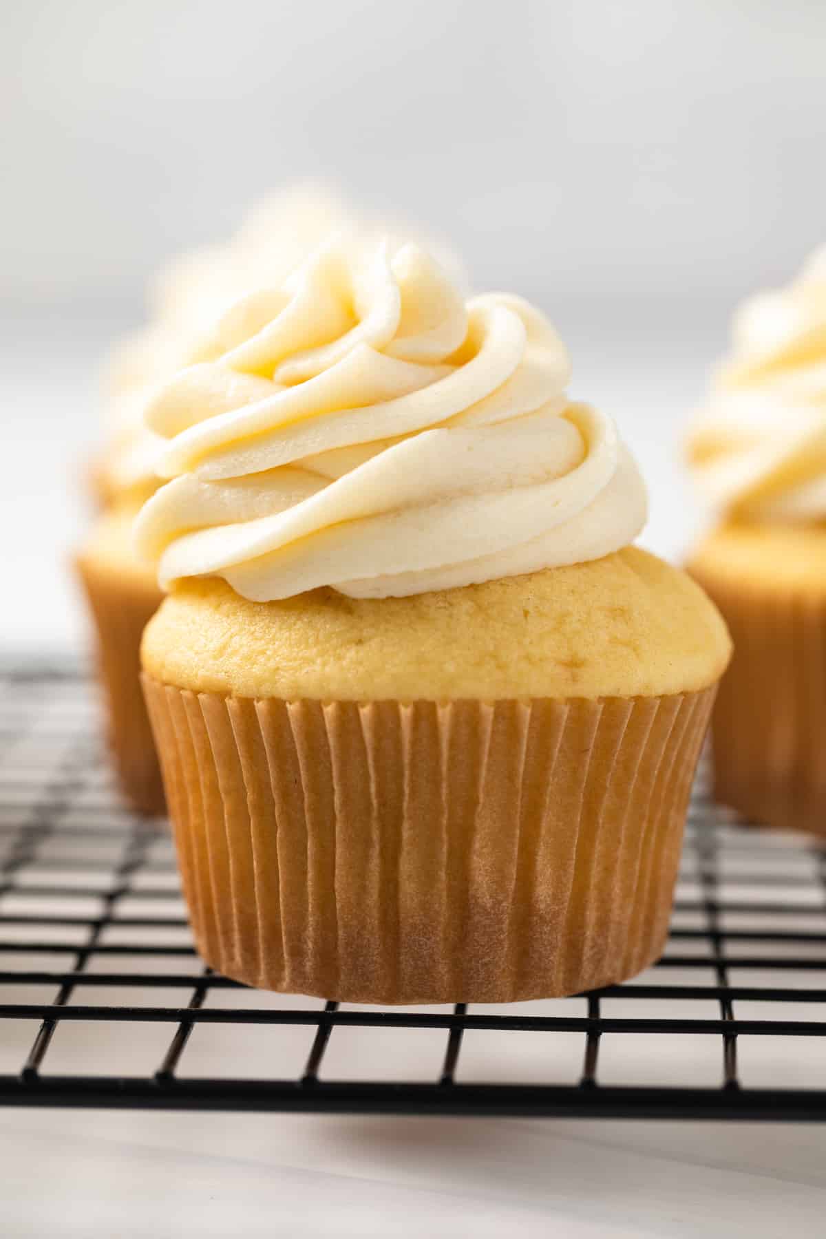 Vanilla cupcakes topped with ermine frosting.